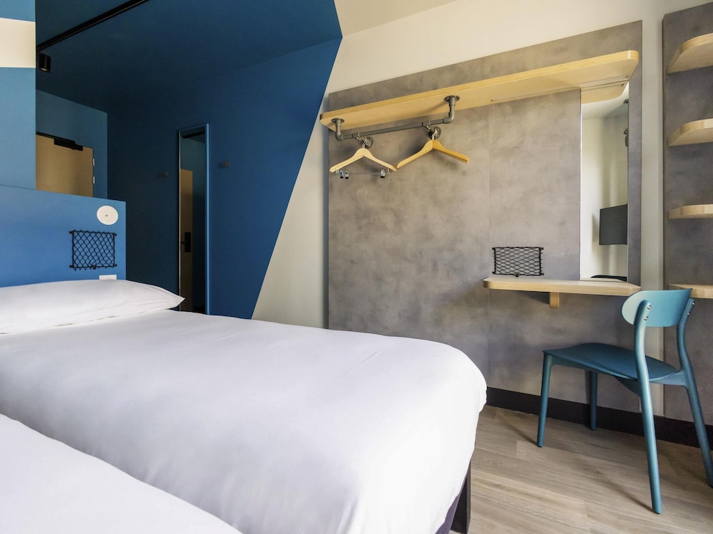 Habitación con dos camas individuales y balcón del hotel ibis budget La Rochelle Centre