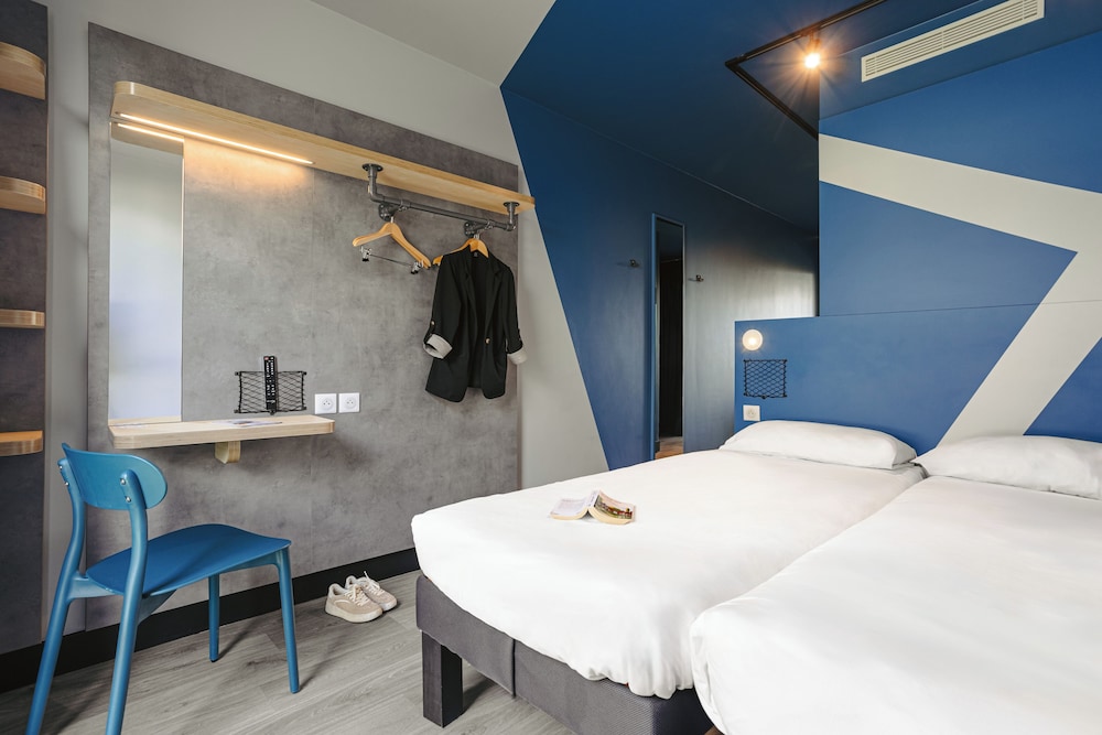 Habitación con dos camas individuales y balcón del hotel ibis budget La Rochelle Centre. Foto 2