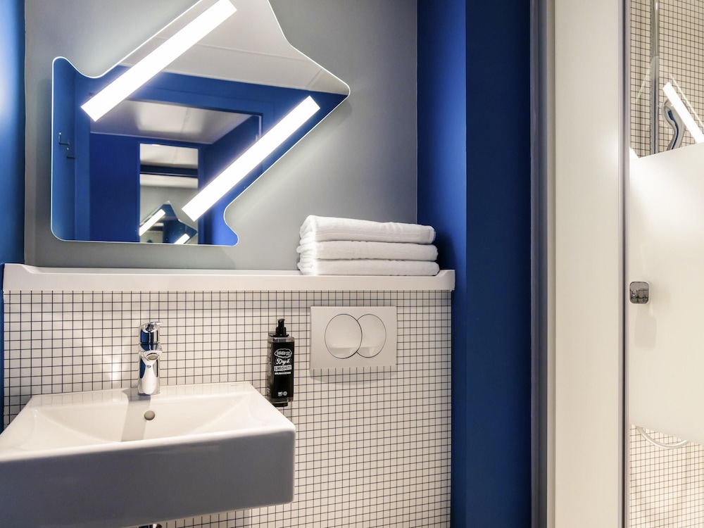 Habitación con dos camas individuales y balcón del hotel ibis budget La Rochelle Centre. Foto 3