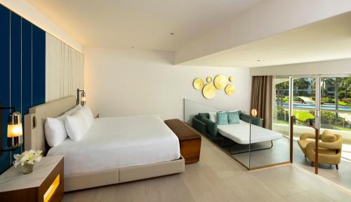 Suite Caribbean Sand con cama extragrande y sofá del hotel Hard Rock and Casino Punta Cana All Inclusive