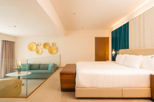 Suite Caribbean con cama extragrande y sofá del hotel Hard Rock and Casino Punta Cana All Inclusive. Foto 3