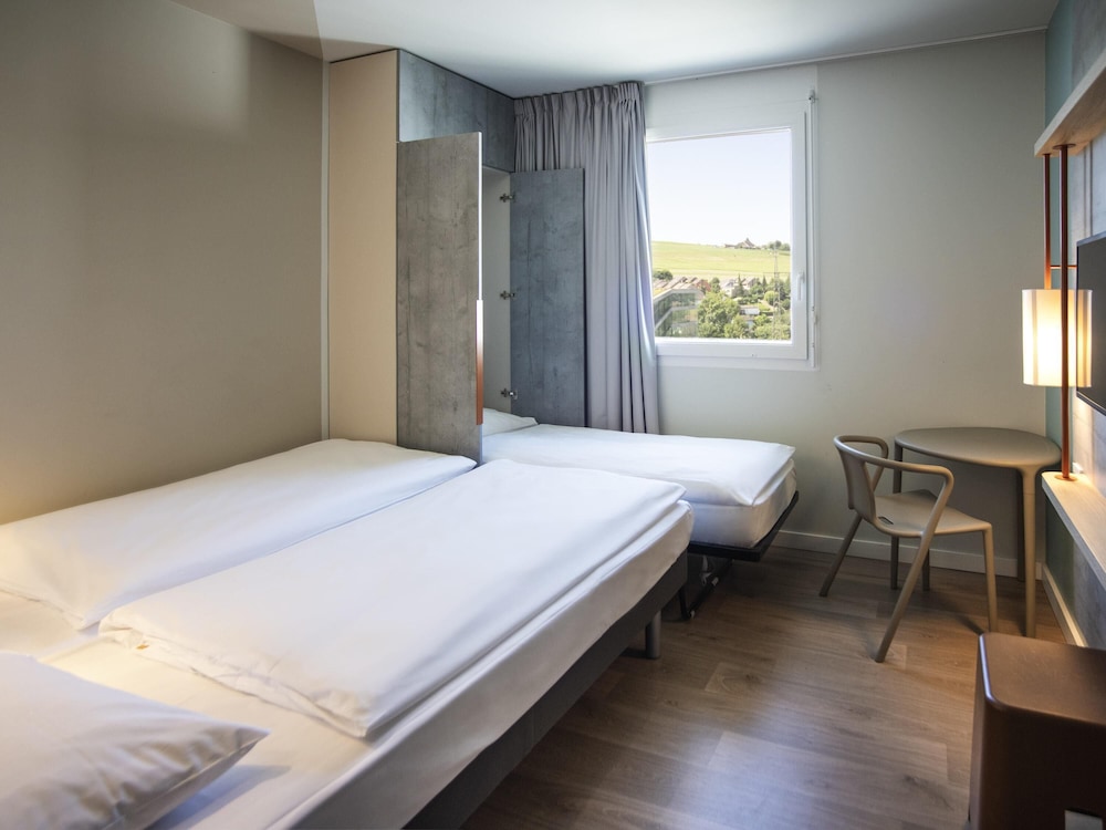 Habitación con 1 cama grande, 1 cama plegable y baño cómodo del hotel ibis budget Fribourg. Foto 7