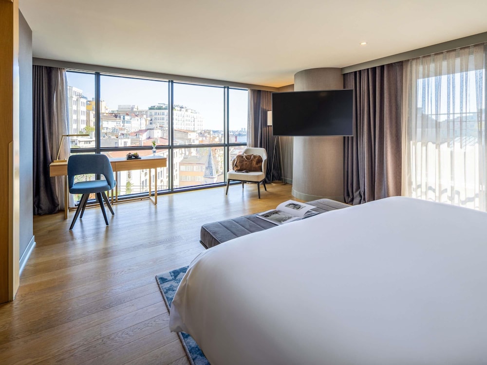 Suite Signature con cama king size, vistas a la plaza Taksim y acceso al Club Millésime del hotel Sofitel Istanbul Taksim