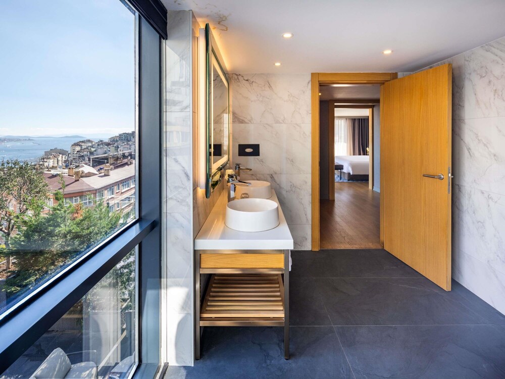 Suite Signature con cama king size, vistas a la plaza Taksim y acceso al Club Millésime del hotel Sofitel Istanbul Taksim. Foto 1