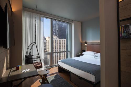 Habitación con cama extragrande y vistas a la ciudad del hotel Moxy NYC Downtown