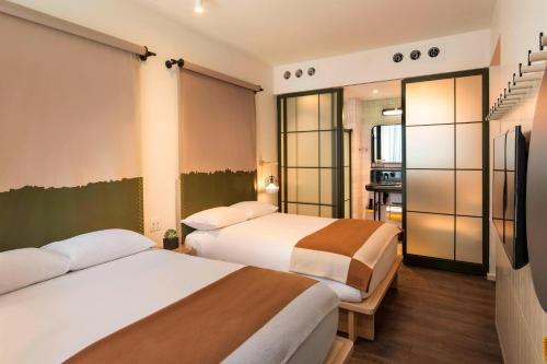 Habitación Doble con 2 camas dobles y vistas a la ciudad del hotel Moxy NYC Chelsea. Foto 1