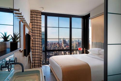 Habitación con cama extragrande y vistas a la ciudad del hotel Moxy NYC Chelsea