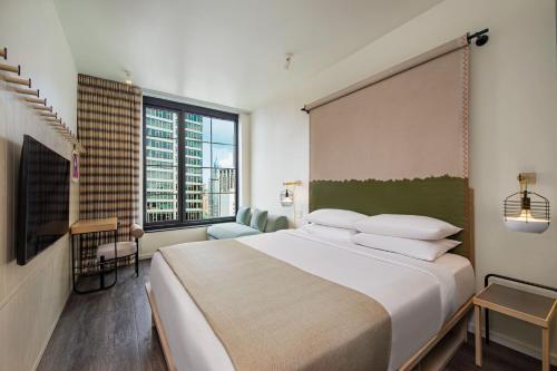 Habitación Executive con cama extragrande y vistas a la ciudad del hotel Moxy NYC Chelsea. Foto 1