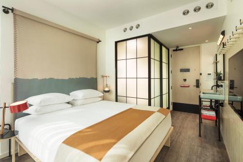 Habitación con cama extragrande y ducha accesible en silla de ruedas - Adaptada para personas con movilidad reducida del hotel Moxy NYC Chelsea