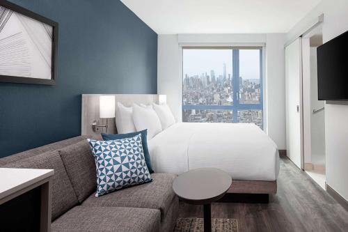 Habitación con cama extragrande, sofá cama y vistas al perfil urbano del hotel Hyatt Place New York / Chelsea. Foto 2