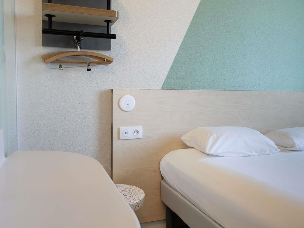 Habitación doble con cama de gran tamaño del hotel Ibis Budget Toulouse Aéroport. Foto 1