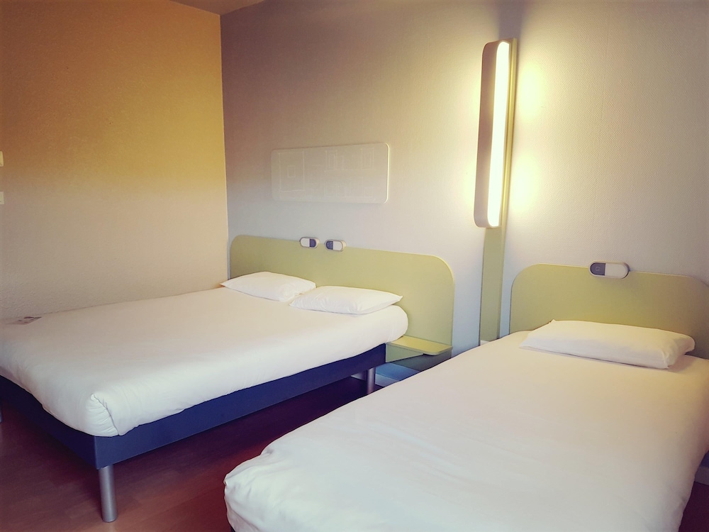 Habitación triple con una cama de gran tamaño y cama individual del hotel Ibis Budget Arles Palais Des Congres. Foto 1