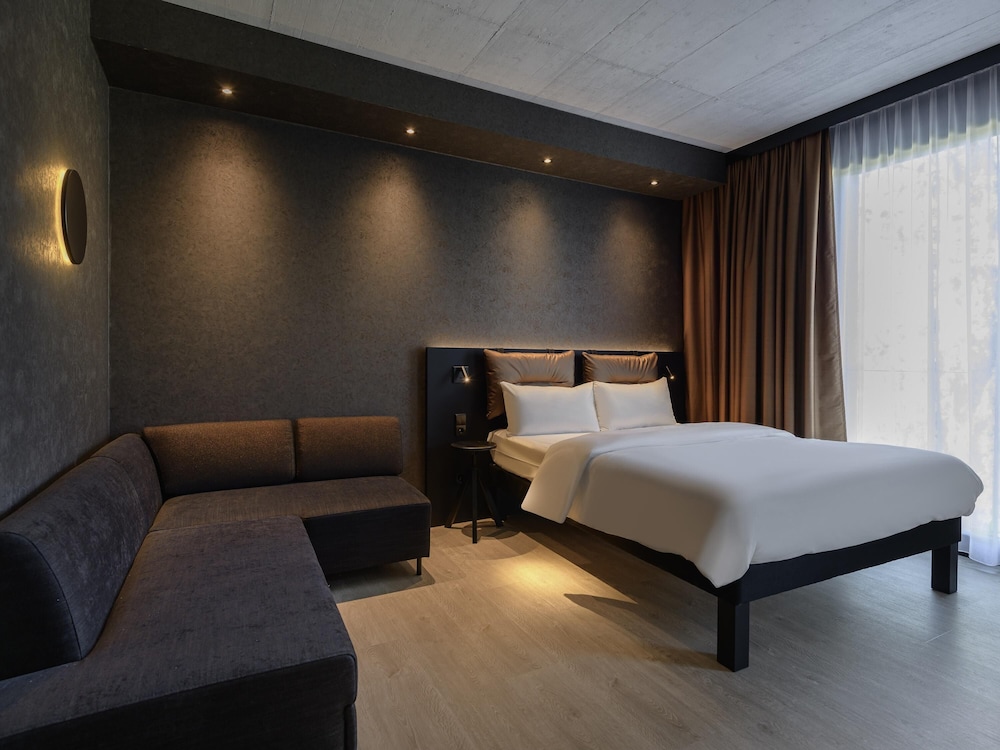 Habitación Confort Espacio Plus ALL con cama doble, sofá - cama y cocina del hotel Ibis Styles Friedrichshafen. Foto 1