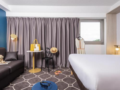 Habitación con cama doble y sofá - cama doble del hotel ibis Styles Sceaux Paris Sud. Foto 1
