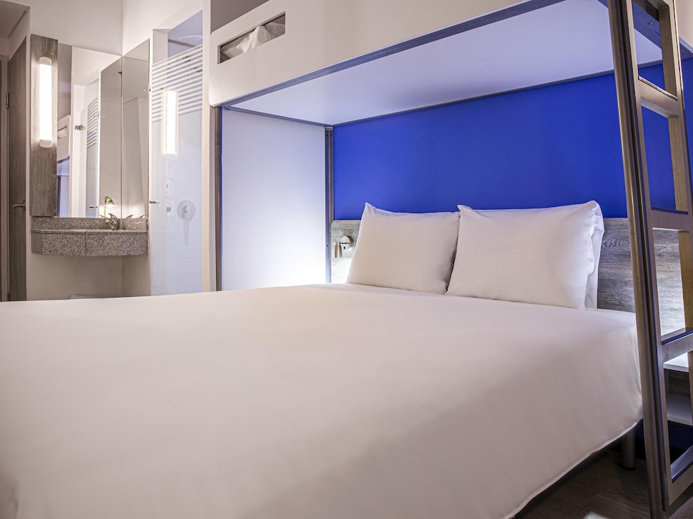 Habitación con una cama doble y una cama adicional del hotel Ibis Budget Barranquilla