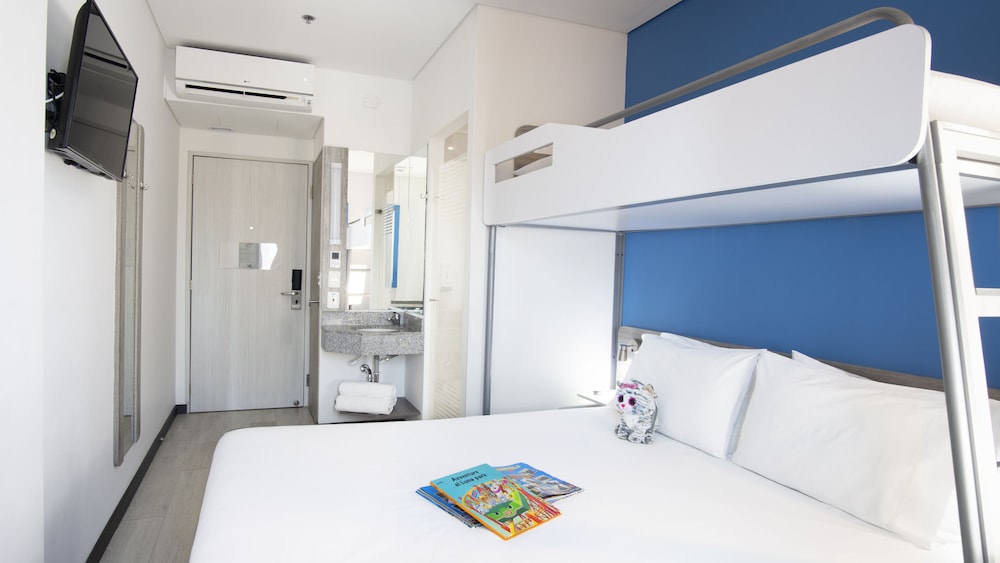 Habitación con una cama doble y una cama adicional del hotel Ibis Budget Barranquilla. Foto 1