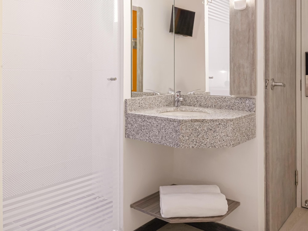 Habitación con una cama doble y una cama adicional del hotel Ibis Budget Barranquilla. Foto 3