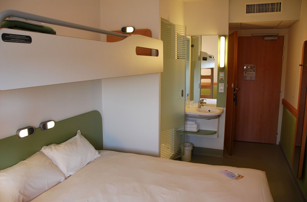 Habitación triple con una cama doble y una litera individual del hotel Ibis Budget Roanne. Foto 1