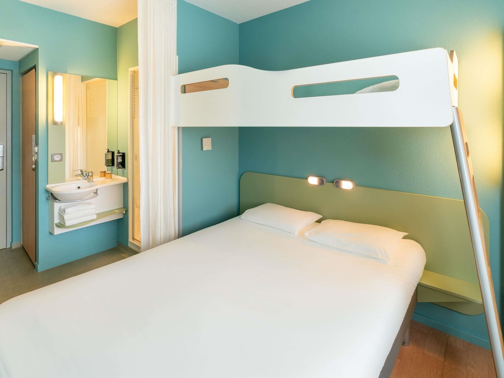 Habitación TRIPLE con una cama de gran tamaño y litera del hotel Ibis Budget Les Sables D'olonne. Foto 8