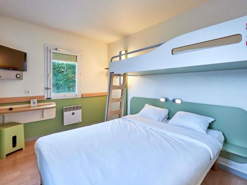 TRIPLE - Habitación con una cama grande y una litera del hotel Ibis Budget Lisieux. Foto 5