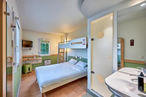 TRIPLE - Habitación con una cama grande y una litera del hotel Ibis Budget Lisieux. Foto 15