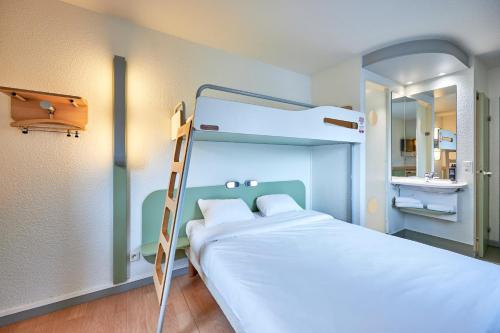 TRIPLE - Habitación con una cama grande y una litera del hotel Ibis Budget Lisieux. Foto 17