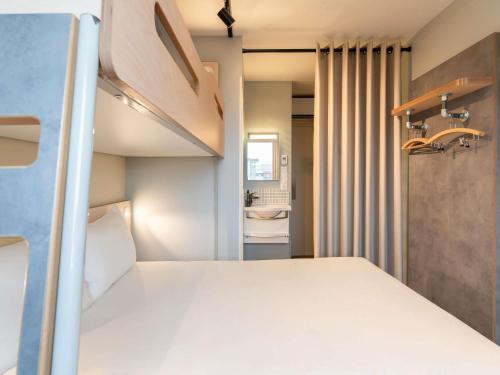 Habitación con una cama grande y una litera del hotel Ibis Budget Issy Les Moulineaux Paris Ouest. Foto 4