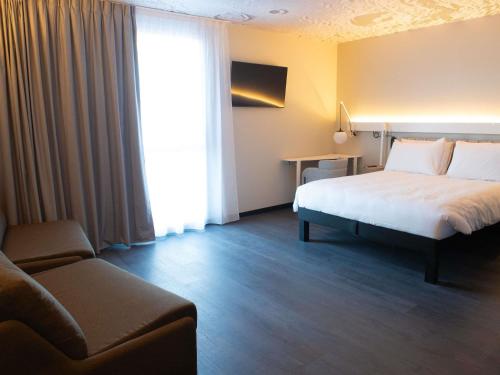Habitación Deluxe con 1 cama doble y 2 sofás - cama individuales del hotel Ibis Montlhery Paris Sud. Foto 5