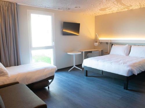 Habitación Deluxe con 1 cama doble y 2 sofás - cama individuales del hotel Ibis Montlhery Paris Sud. Foto 7