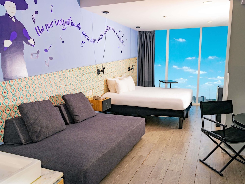 Junior Suite con una cama king - size y un sofa cama para dos personas del hotel Ibis Styles Merida Galerias
