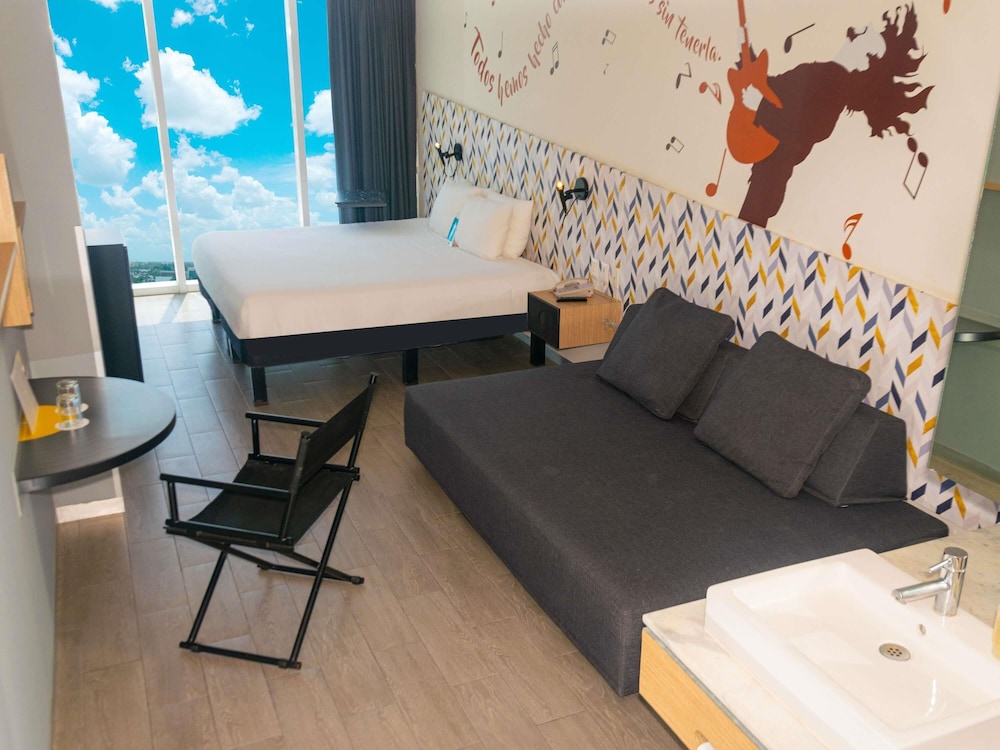 Junior Suite con una cama king - size y un sofa cama para dos personas del hotel Ibis Styles Merida Galerias. Foto 4