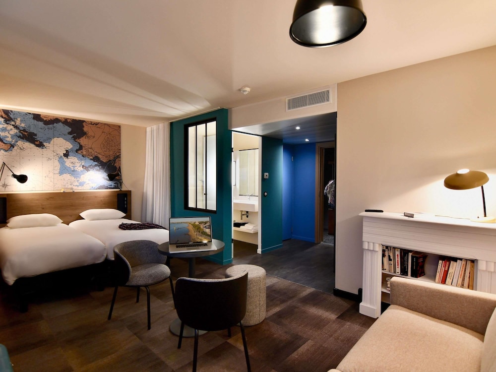 Suite con cama doble y sofá del hotel Ibis Styles Saint Nazaire Centre Gare