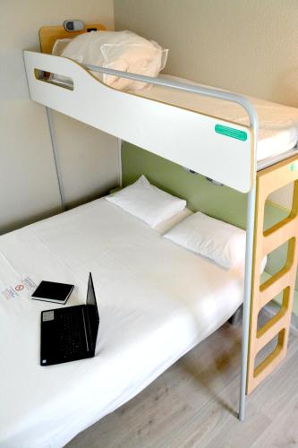 TRIPLE - Habitación con una cama grande y una cama litera del hotel Ibis Budget Rouen Parc Des Expos Zenith. Foto 1