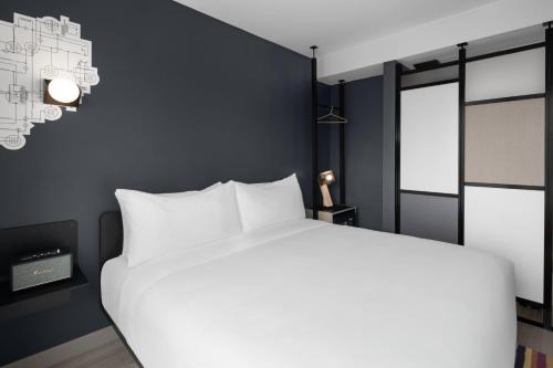 Habitación con cama extragrande y vistas a la ciudad del hotel Aloft New York Chelsea. Foto 8