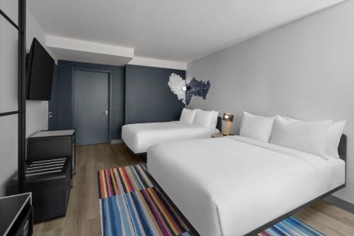 Habitación Queen con dos camas queen, vista a la ciudad y ducha roll‑in, accesible para movilidad reducida y discapacidad auditiva del hotel Aloft New York Chelsea. Foto 1