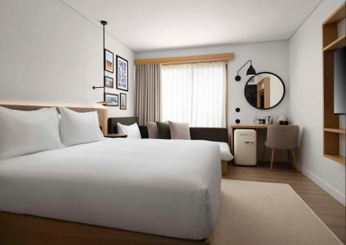 Habitación con cama extragrande y sofá cama del hotel Hilton Garden Inn Evora. Foto 3