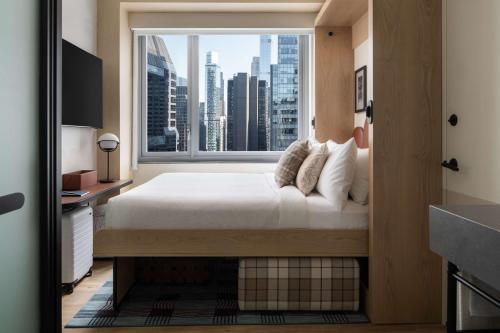 Habitación con cama grande, vistas a la ciudad y cama de pared del hotel Motto By Hilton New York City Times Square. Foto 7