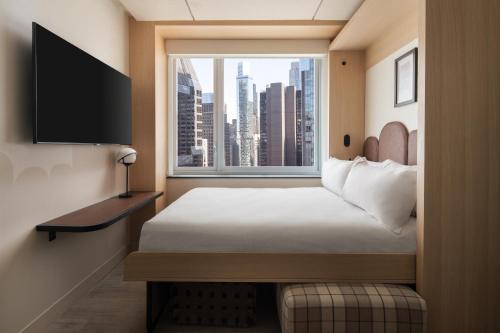 Habitación con cama grande, vistas a la ciudad y cama de pared del hotel Motto By Hilton New York City Times Square. Foto 11