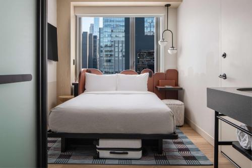 Habitación compacta con cama grande y vistas a la ciudad del hotel Motto By Hilton New York City Times Square. Foto 5