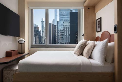 Habitación compacta con cama grande y vistas a la ciudad del hotel Motto By Hilton New York City Times Square. Foto 10