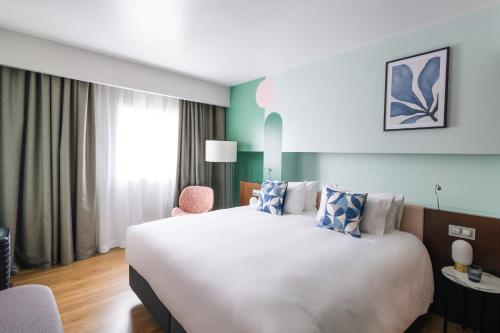 Suite con cama extragrande y sofá cama del hotel Voco Madrid - Retiro, an IHG