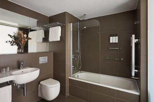 Suite con cama extragrande y sofá cama del hotel Voco Madrid - Retiro, an IHG. Foto 3