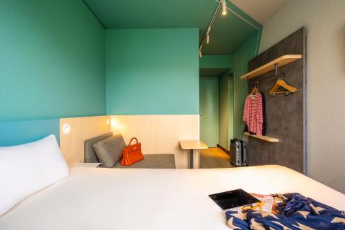 Habitación estándar compacta con 1 cama doble y una silla reclinable del hotel ibis budget Berlin Kurfürstendamm. Foto 3
