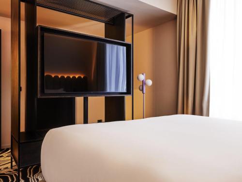 Suite con cama doble y sofá cama del hotel Tribe Milano Malpensa. Foto 9
