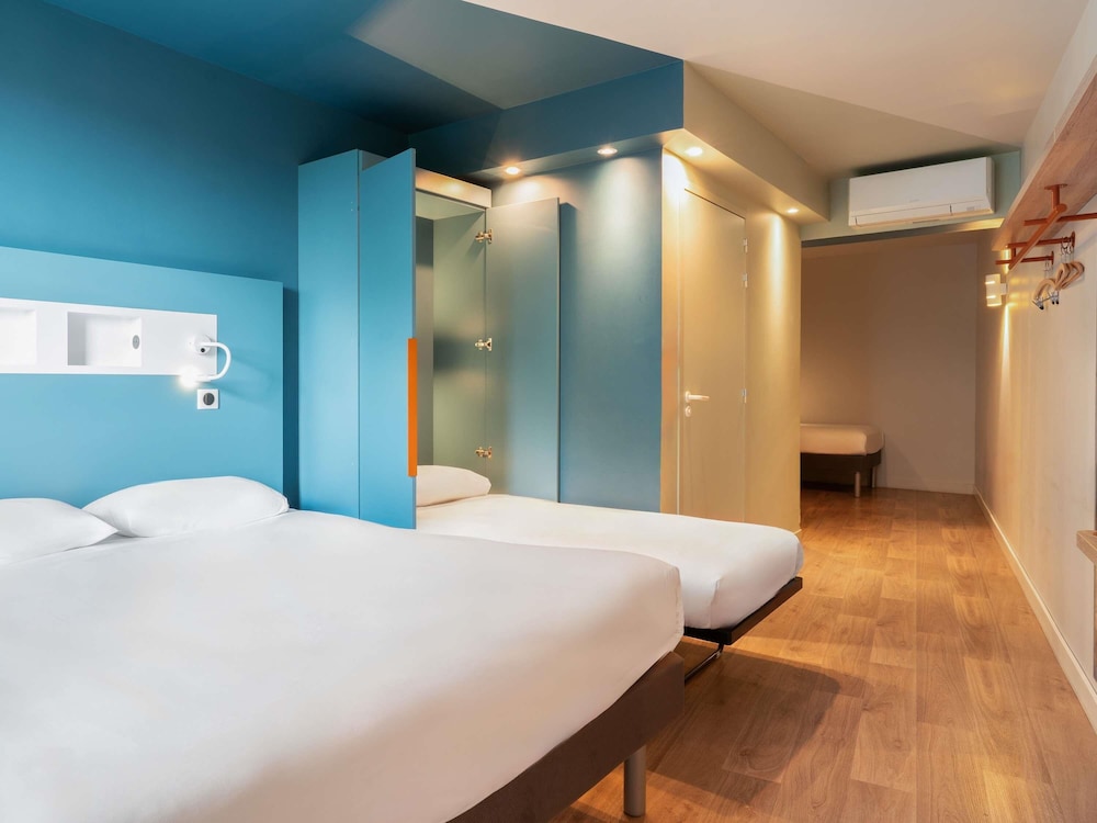 Habitación con 1 cama doble y 2 camas individuales del hotel ibis budget Rouen Centre Rive Gauche. Foto 3