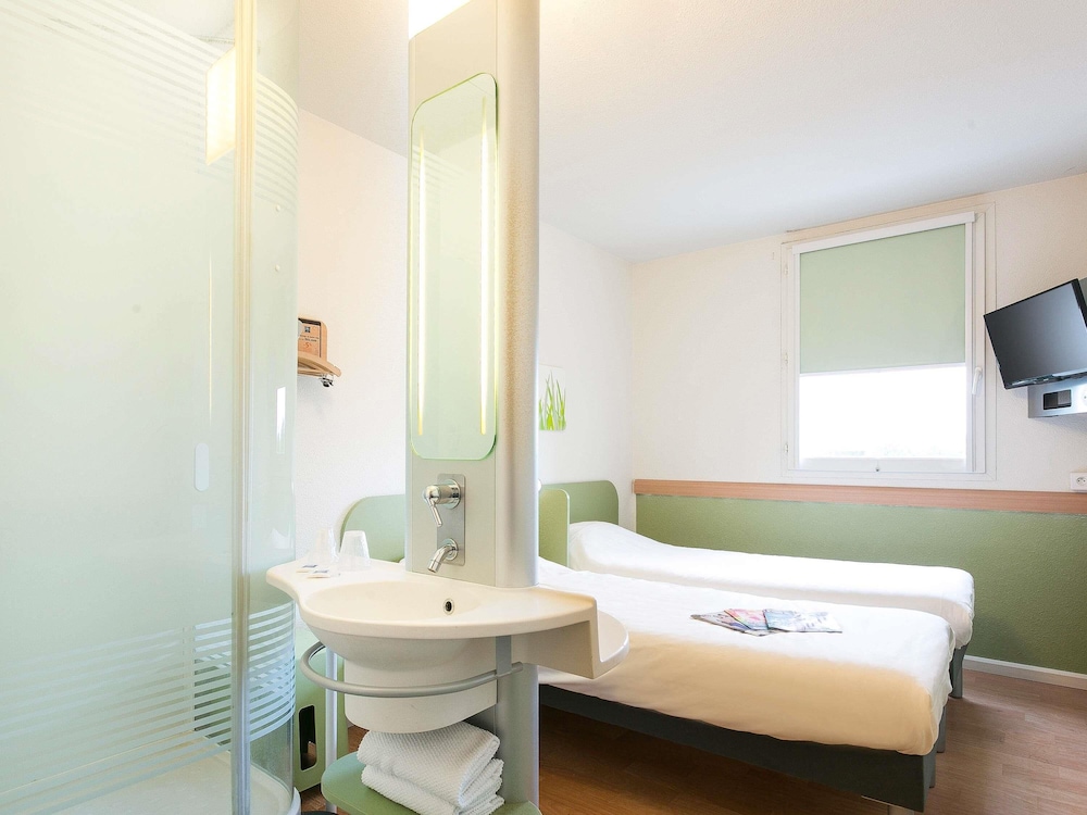 Habitación con dos camas individuales del hotel ibis budget Bordeaux Aeroport. Foto 2