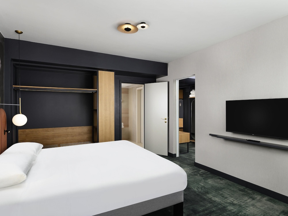 Suite de un dormitorio con una cama doble y sofá cama del hotel Mercure Debrecen. Foto 1