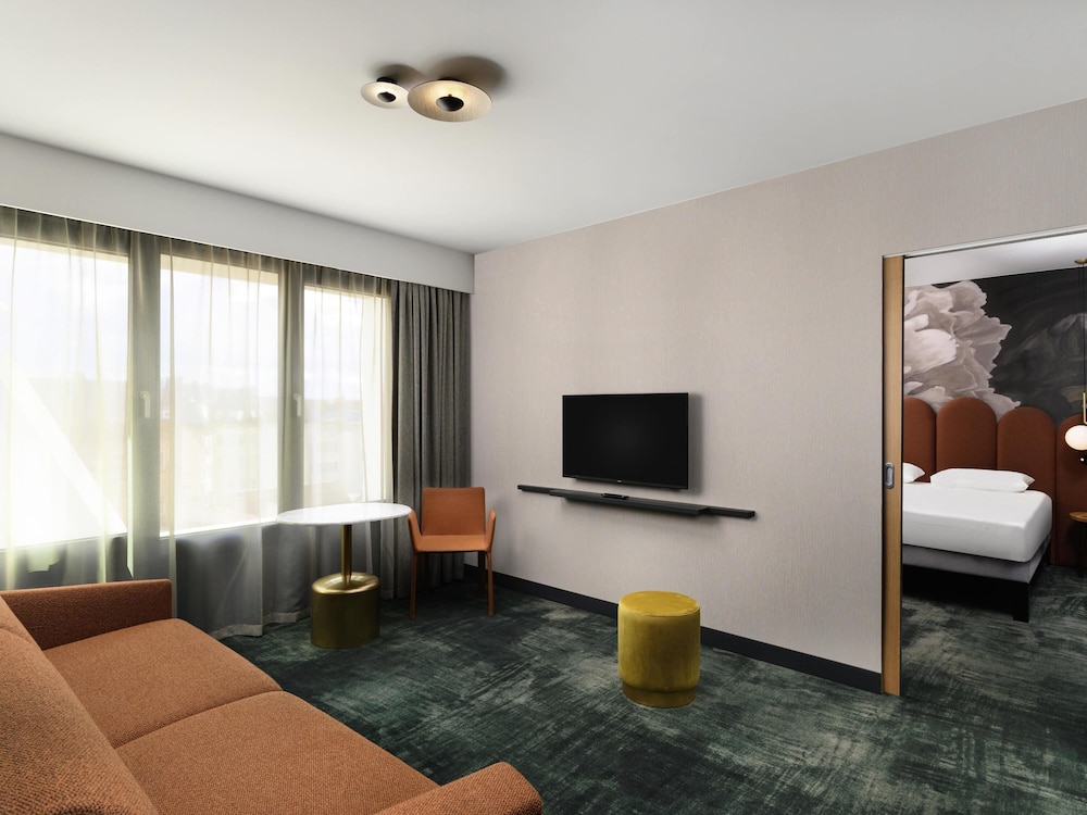 Suite de un dormitorio con una cama doble y sofá cama del hotel Mercure Debrecen. Foto 3