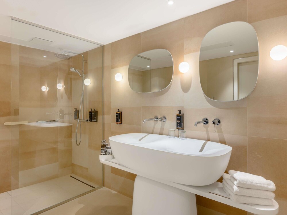 Suite de un dormitorio con una cama doble y sofá cama del hotel Mercure Debrecen. Foto 5