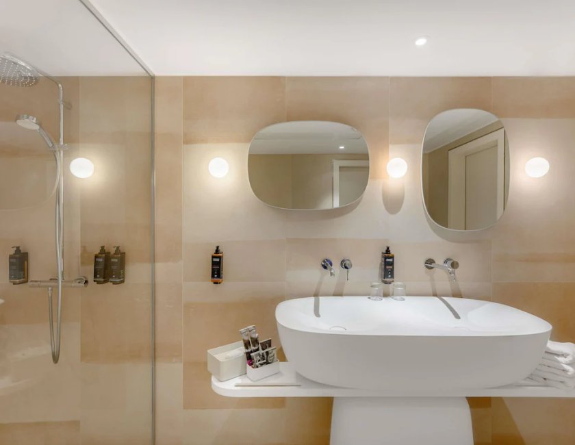 Suite de un dormitorio con una cama doble y sofá cama del hotel Mercure Debrecen. Foto 7